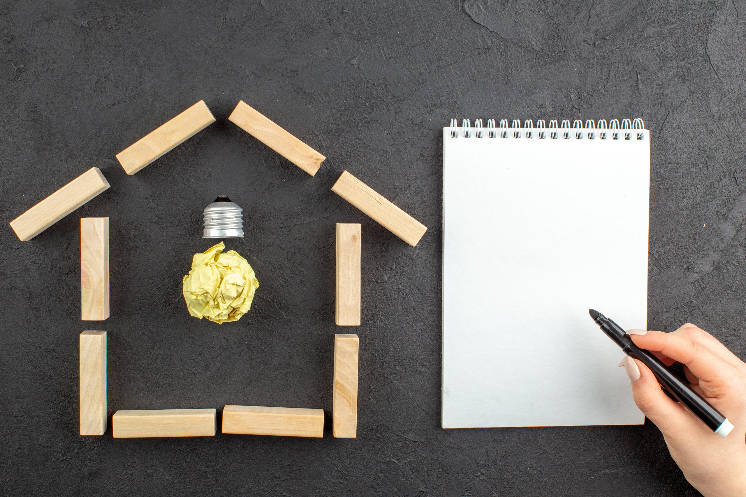top-view-idealight-bulb-house-shaped-wood-blocks-notepad-black-marker-female-hand-black Home Villa Purchase
